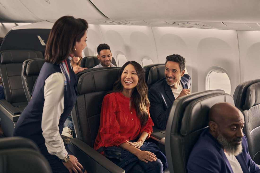 A flight attendant welcoming customers on board
