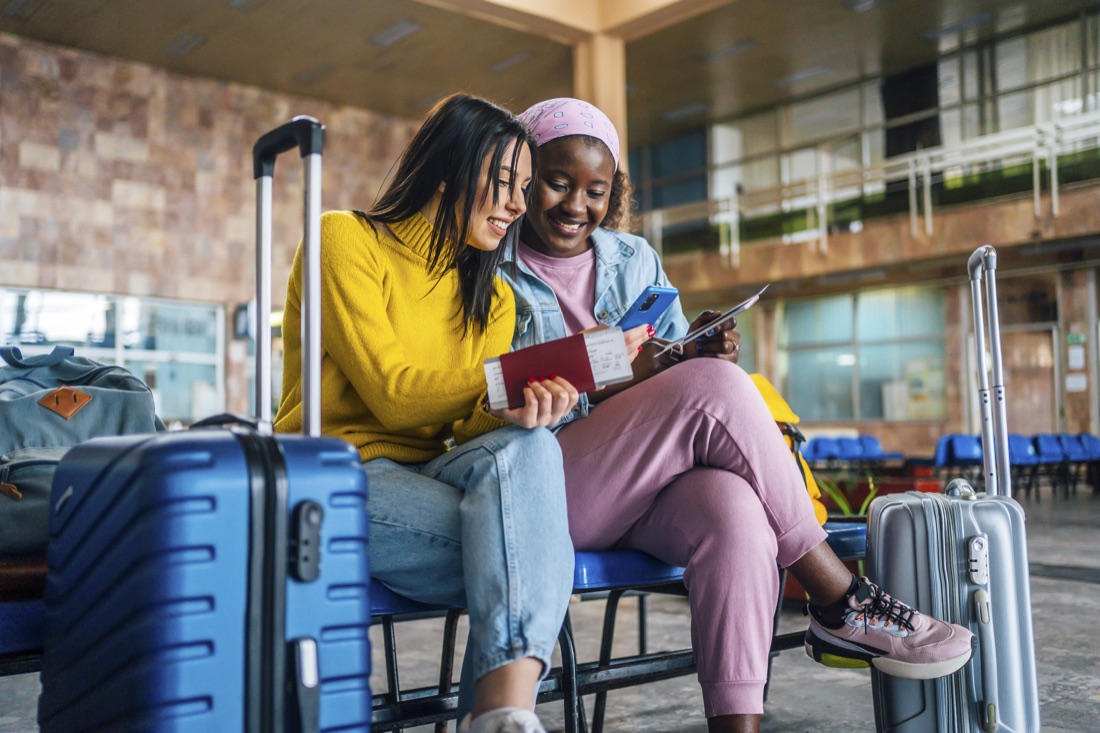 Two friends checking travel details with their passports